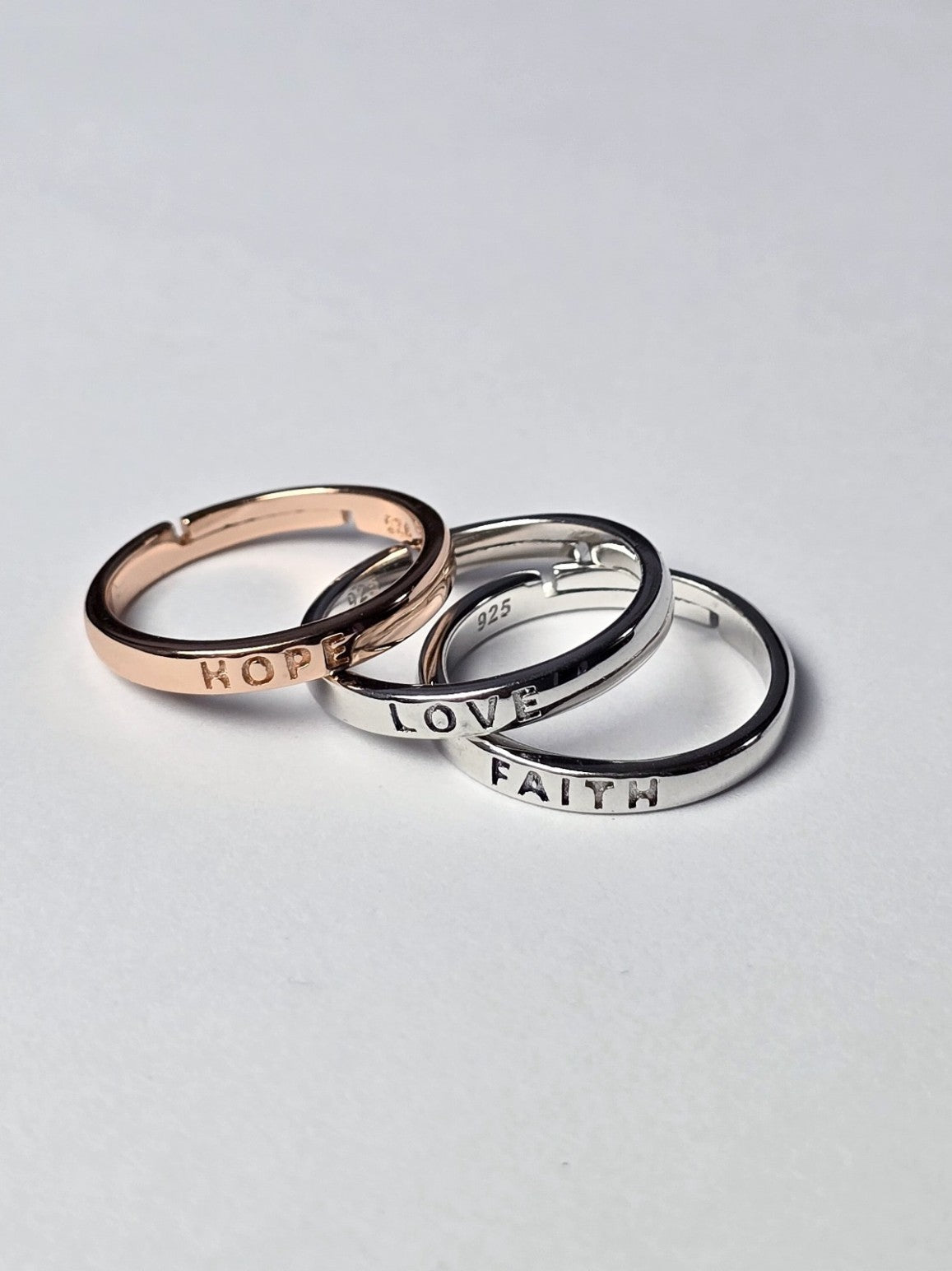 Three rings with 'HOPE', 'LOVE', and 'FAITH' inscriptions on a light gray background